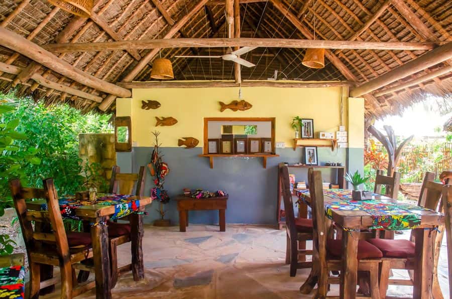 Thatched restaurant with wooden tables and local decoration