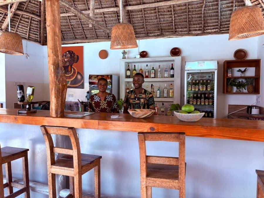 The bar counter with drinks and wooden stools